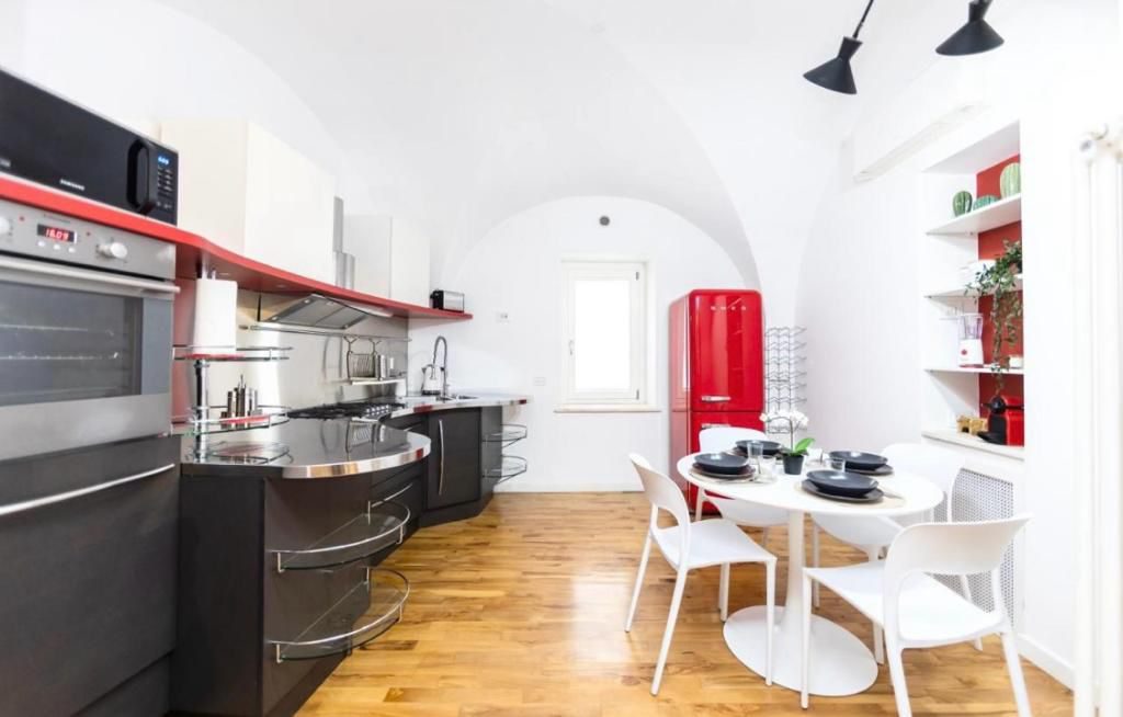 Cucina completa con frigorifero Smeg rosso e tavolo da pranzo