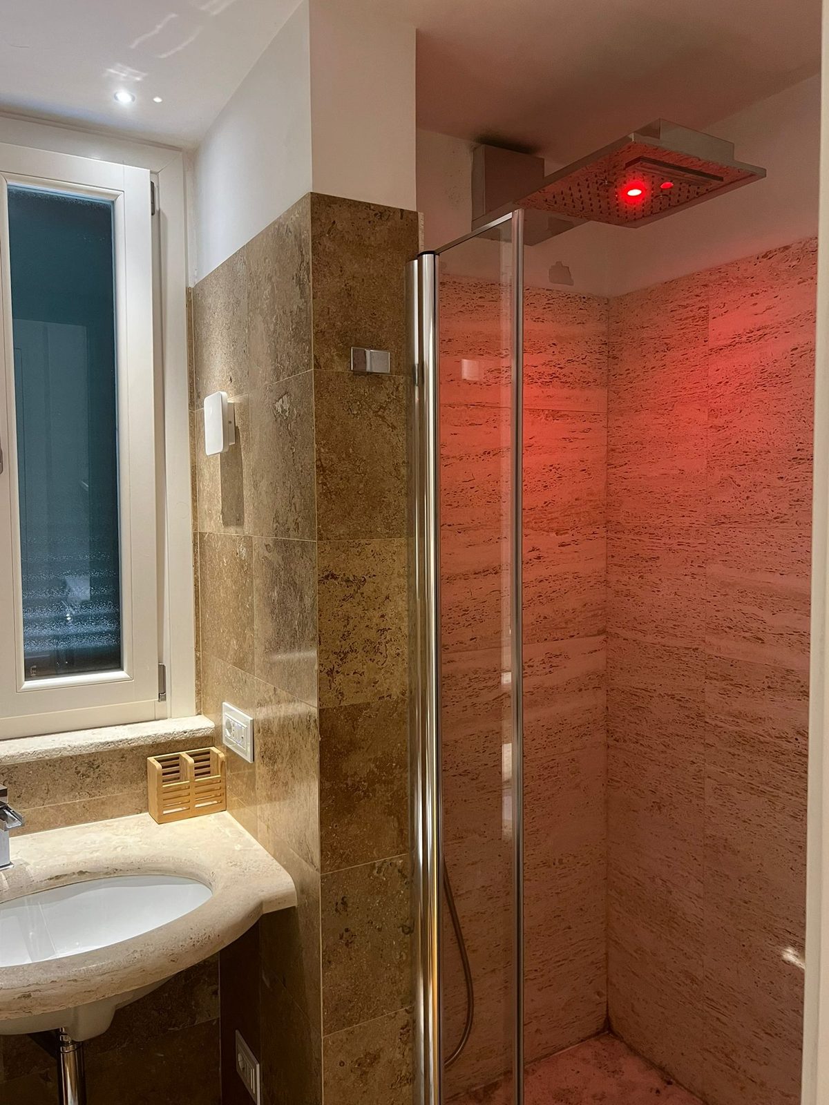 Doccia in travertino con luce cromoterapica rossa